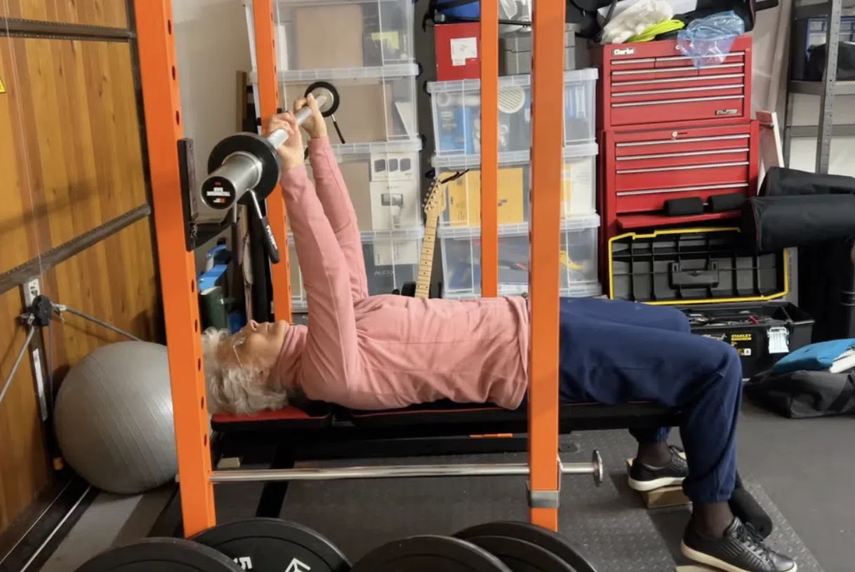 Vrouw op leeftijd doet een bench press.